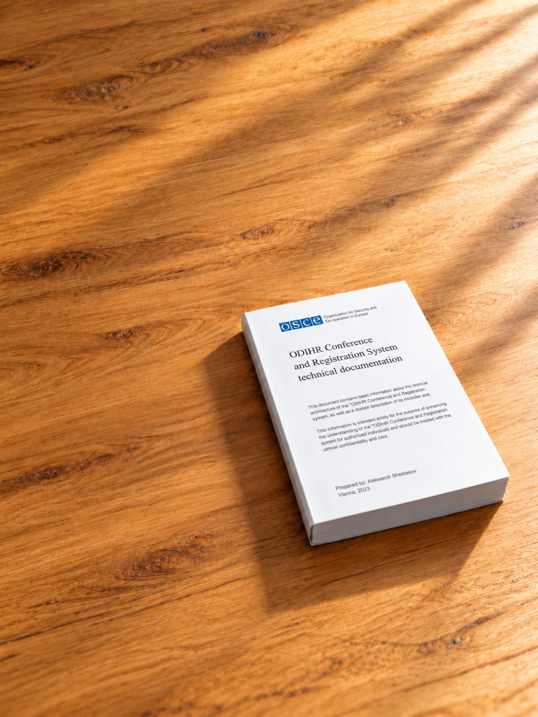 Printed ODIHR Conference and Registration System technical documentation on a wooden surface
